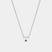 Silver necklace with a small round pendant on a light gray background
