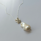 Infinity-shaped pendant featuring baroque shaped freshwater pearl. 