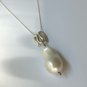 Infinity-shaped pendant featuring baroque shaped freshwater pearl. 