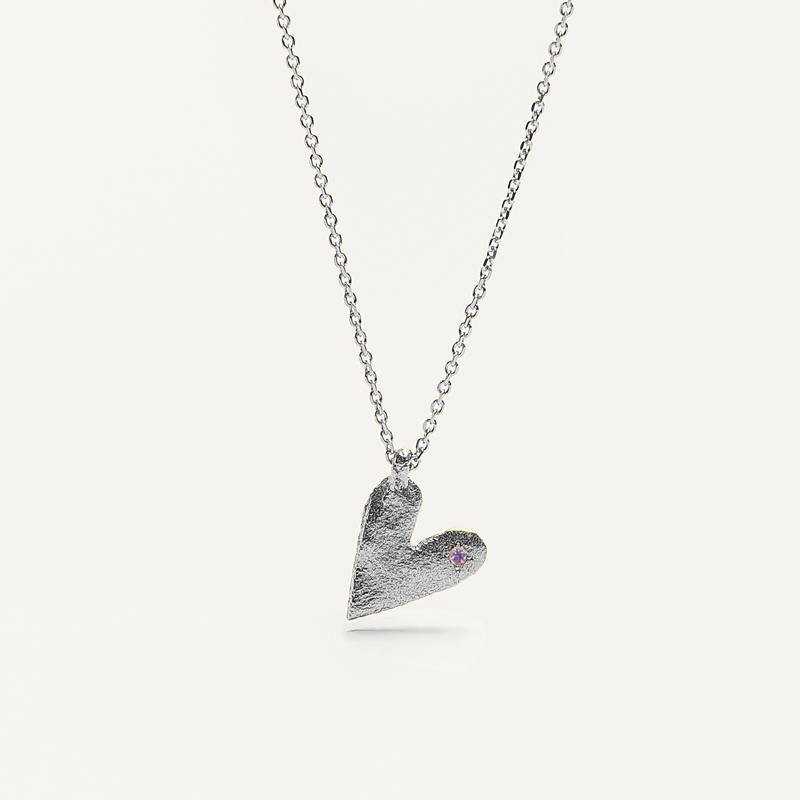 Silver heart-shaped pendant necklace with a purple gemstone on a white background