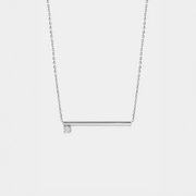 Silver necklace with a zirconium  pendant on a light gray background