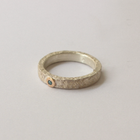 Silver ring with blue diamond on a light gray background