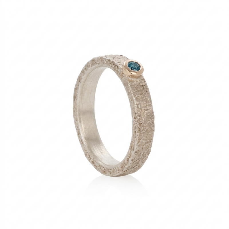 Silver ring with a blue gemstone on a white background
