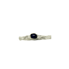 A silver ring with a sapphire stone set in a ornate setting, with a textured band and a narrow stone.