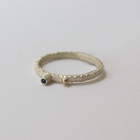 Silver ring with a gold accent and blue sapphire on a light gray background
