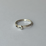 A silver ring with blue sapphires set in it, presented on a white background.