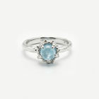 Silver ring with a light blue topaz on a white background