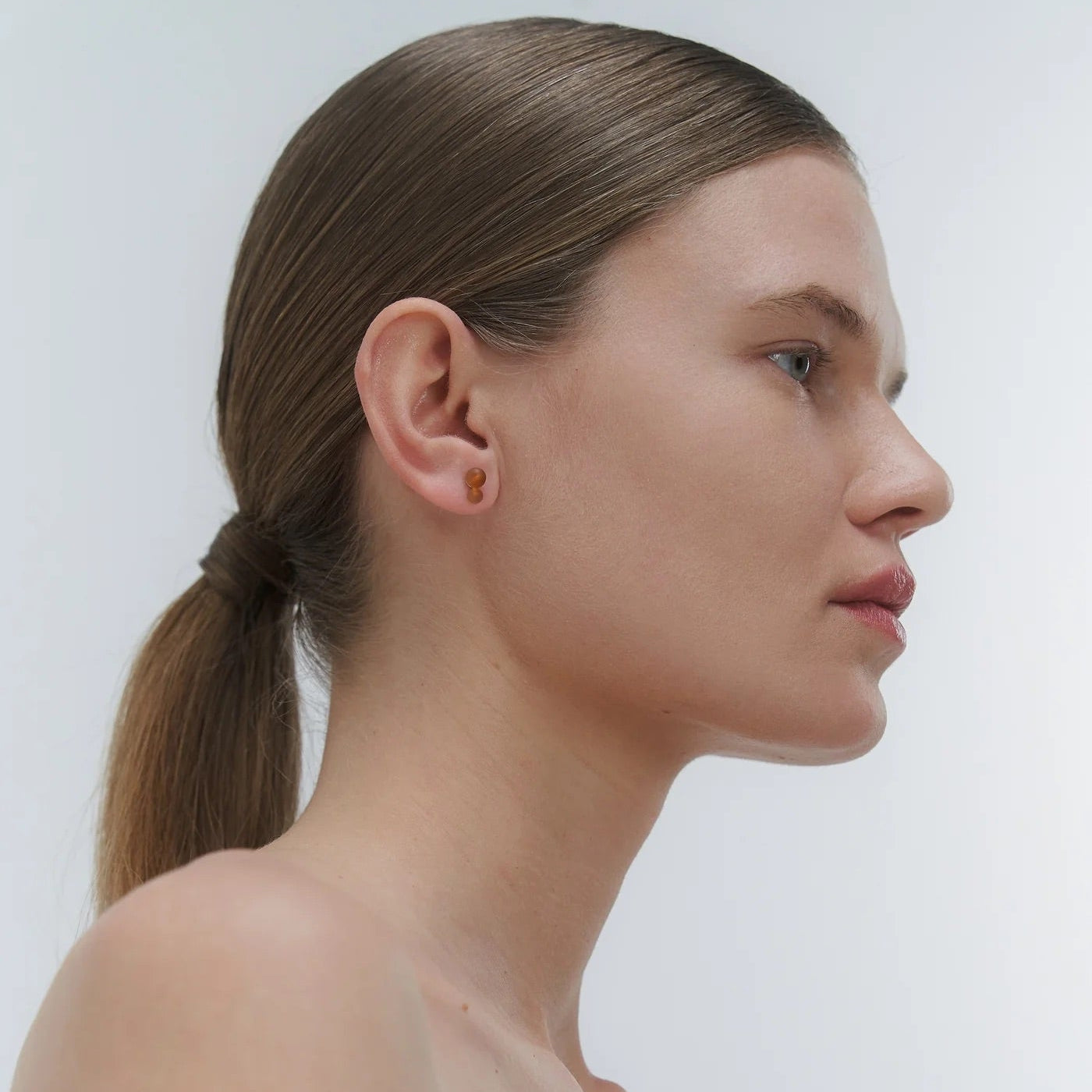 Silver stud earrings, featuring Baltic amber by Adele Notes.