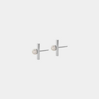 A pair of silver stud earrings with a round pearl attached to silver string, against a white background.