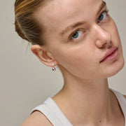 Close-up of a woman wearing earrings with a neutral background