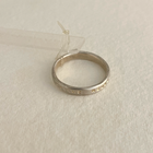 A polished thin silver ring with Latin inscription, displayed against a neutral background.
