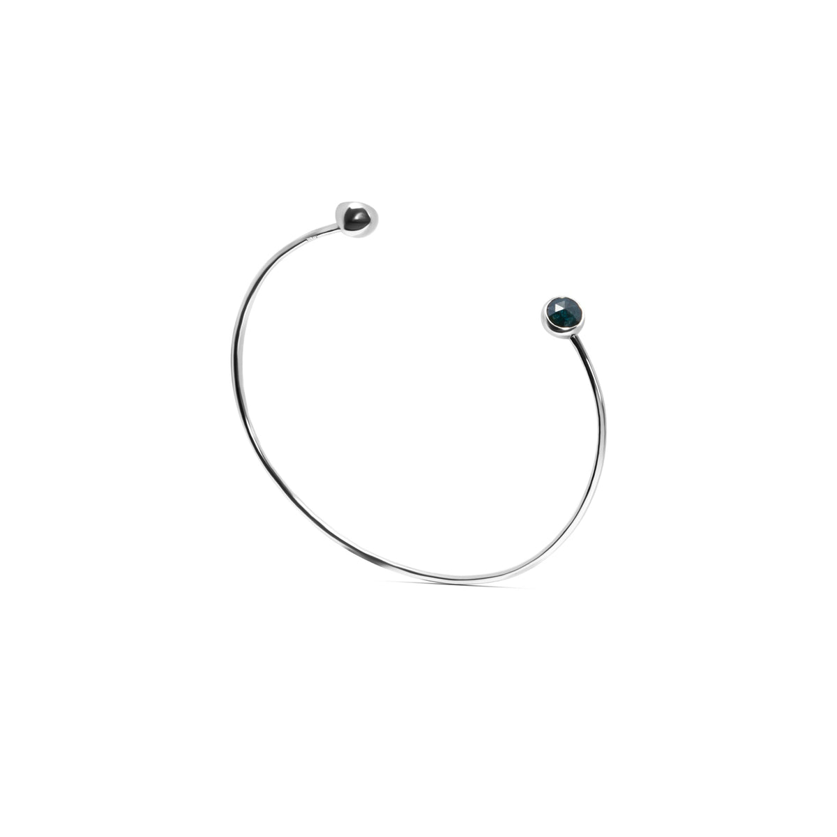 A delicate gold open cuff bracelet with a small dark blue faceted diamonds set in each end, shown on a plain white background.