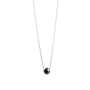 A delicate gold necklace with a faceted diamond pendant, displayed on a clean white background.