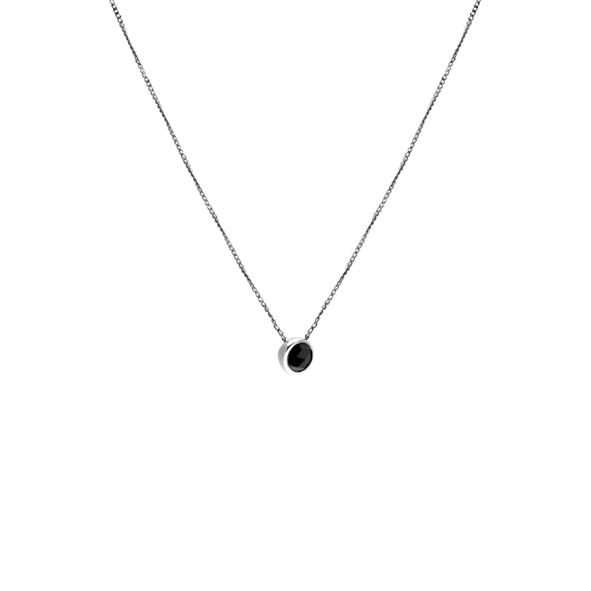 A delicate white gold chain necklace with a small bezel-set ocean blue diamond pendant, shown against a plain white background.