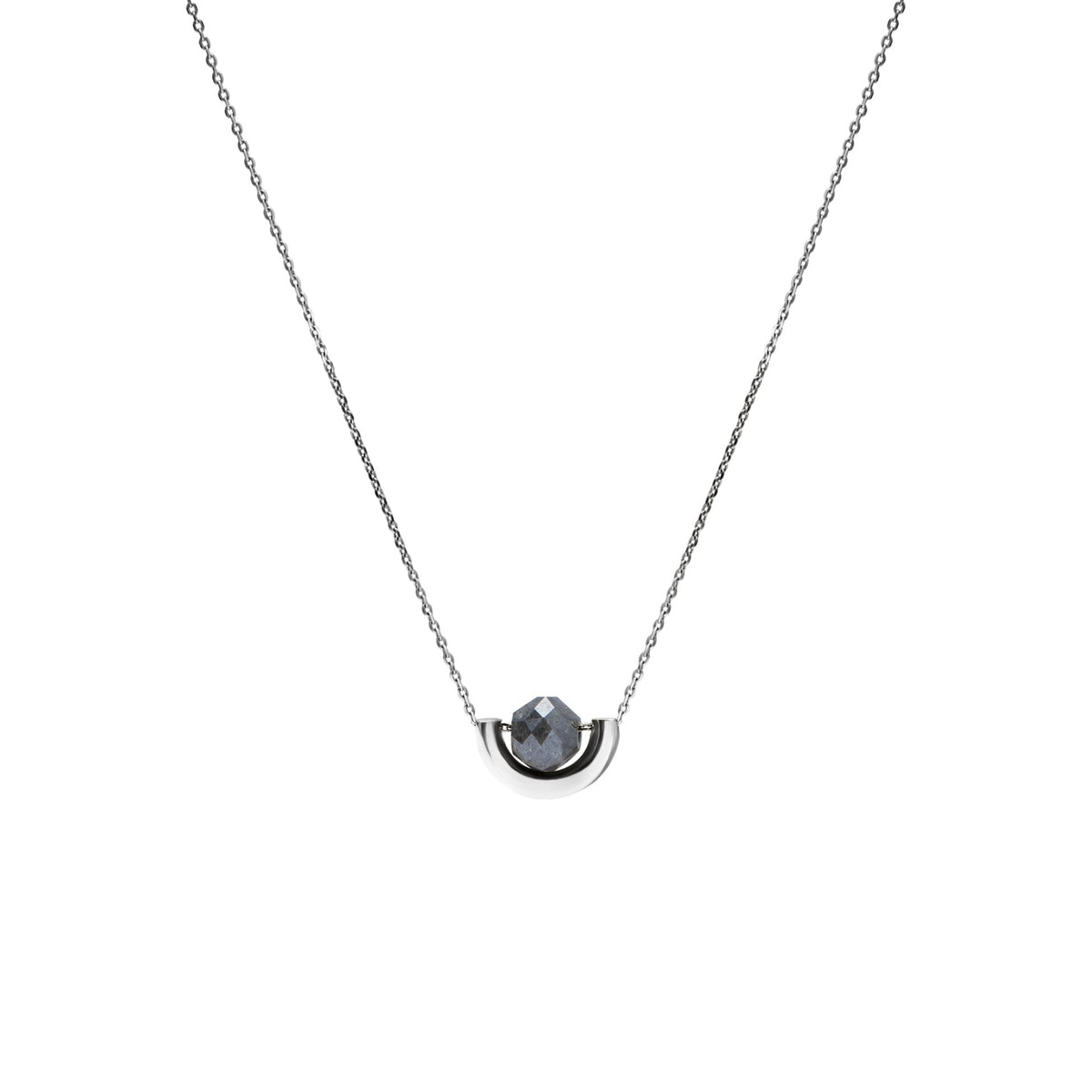 A delicate white gold chain necklace featuring a small, polished gold crescent-shaped setting holding a round, dark gray diamond, presented on a solid white background.