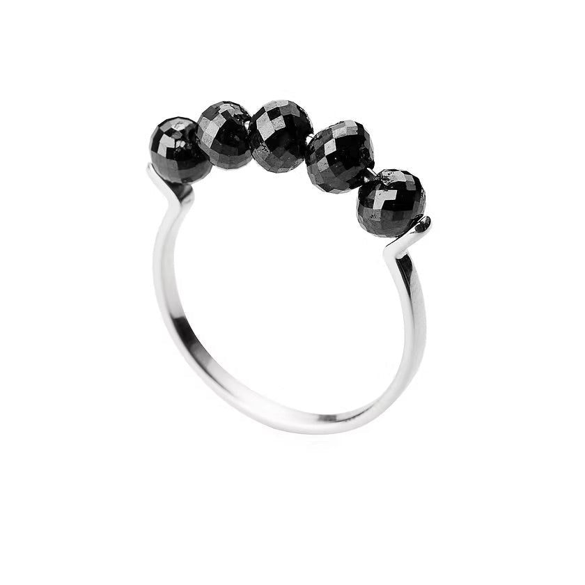 A white gold ring featuring five faceted black diamonds beads set across the top, photographed on a clean white background.