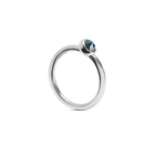 A white gold ring with a single faceted dark ocean blue gemstone in a bezel setting, shown on a clean white background.