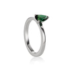 A white gold ring featuring a faceted pear-cut tourmaline gemstone in a three-prong setting, displayed on a clean white background with a soft reflection.