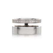 A polished white gold ring shown open, with one half featuring a row of clear pavé stones and the other half plain, on a white background.