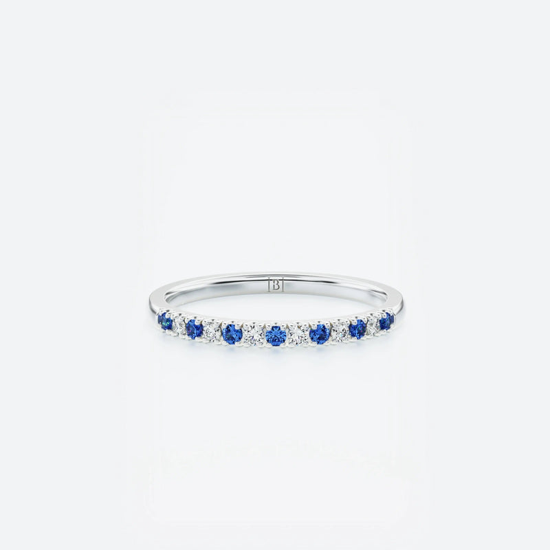 White gold ring with small diamonds & blue sapphires on a white background