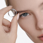 Woman holding white gold ring featuring a torsion band design with inset laboratory-made diamonds.
