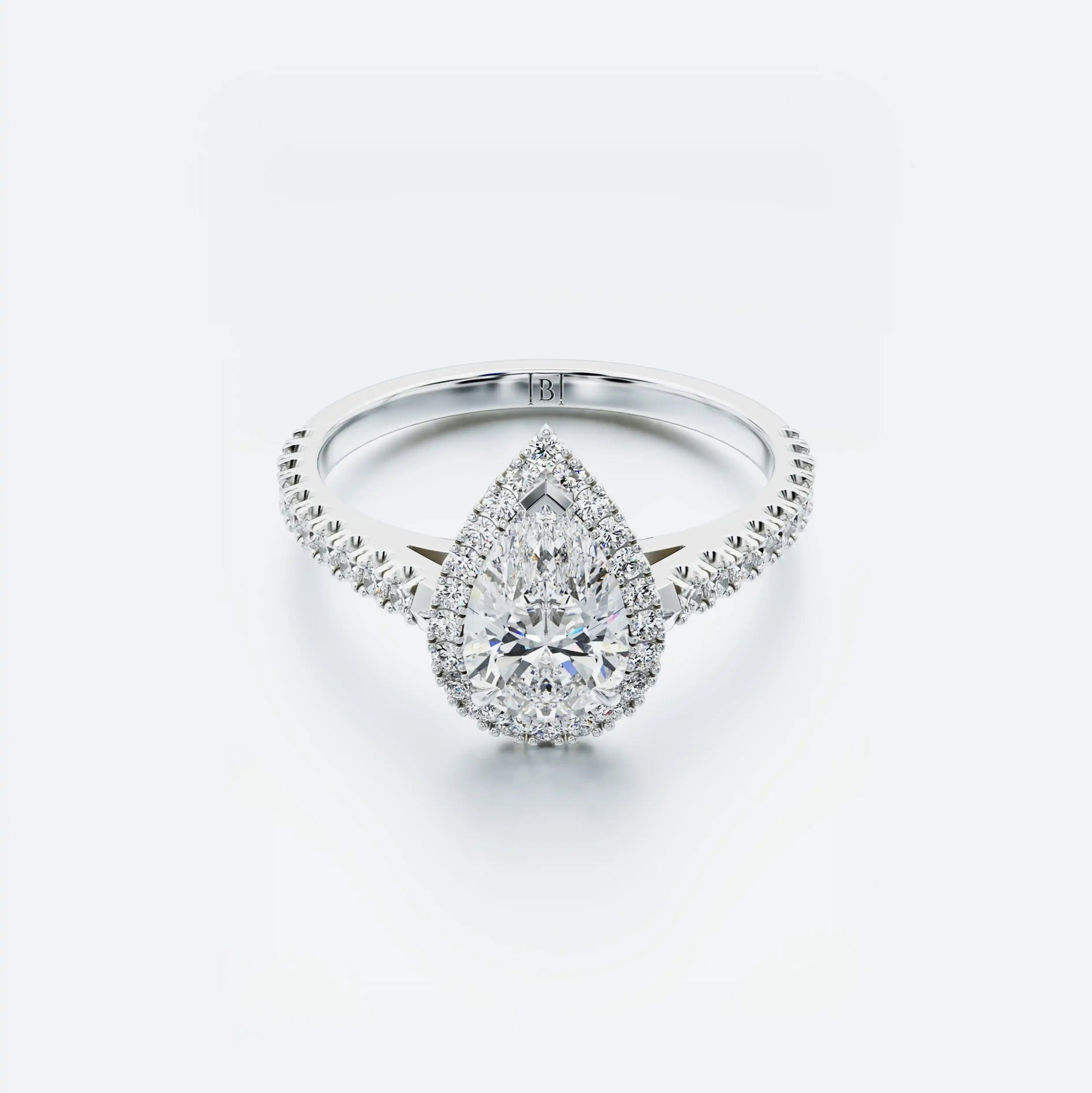 Diamond ring with a pear-shaped center stone on a white background