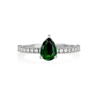 Ring with a green pear-shaped tourmaline and diamond-studded band on a white background