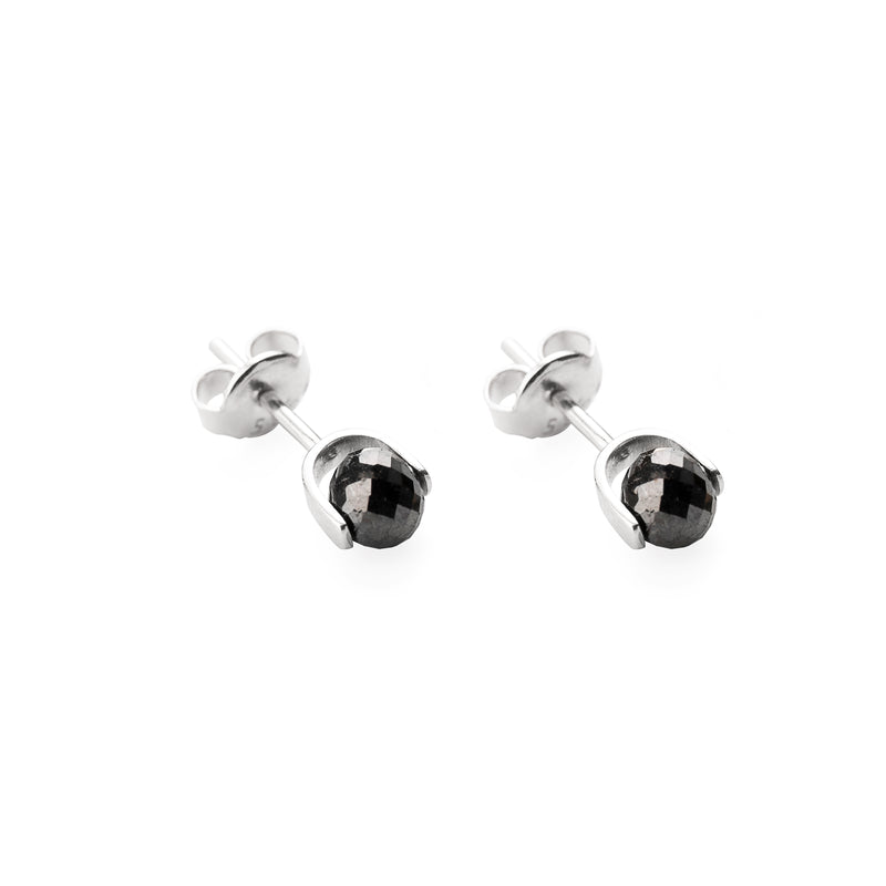A pair of white gold stud earrings with faceted black diamonds, shown on a clean white background.