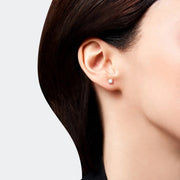 Close-up of a person wearing a classic stud earring crafted from 14k white gold, featuring brilliant diamond.
