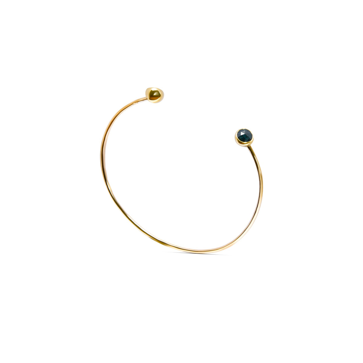 A delicate gold open cuff bracelet with a small dark blue faceted diamonds set in each end, shown on a plain white background.