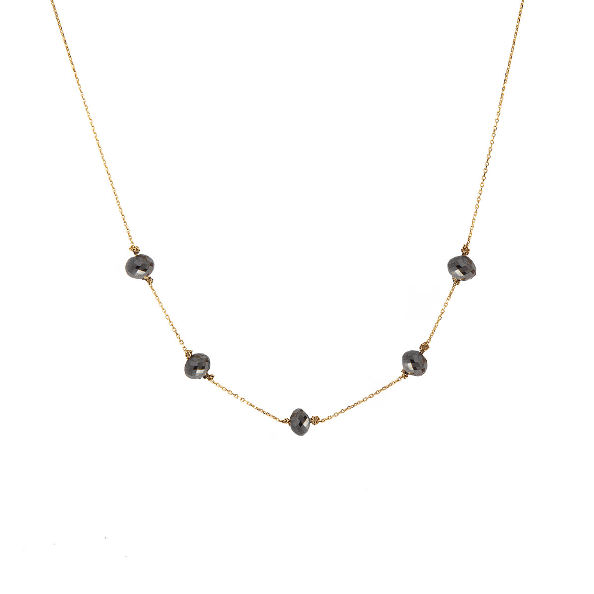 A delicate yellow gold chain necklace featuring five small, dark, faceted diamonds spaced along the front, displayed against a solid white background.