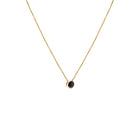 A delicate gold chain necklace with a small bezel-set ocean blue diamond pendant, shown against a plain white background.