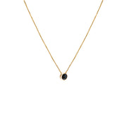 A delicate gold chain necklace with a small bezel-set ocean blue diamond pendant, shown against a plain white background.