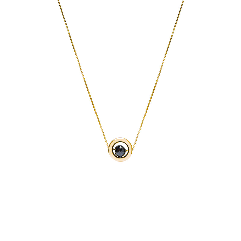 A delicate gold chain necklace featuring a small circular pendant with a gold outer ring and a dark, nearly black, faceted diamond, shown against a plain white background.