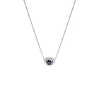 A delicate white gold chain necklace featuring a small circular pendant with a gold outer ring and a dark, nearly black, faceted diamond, shown against a plain white background.