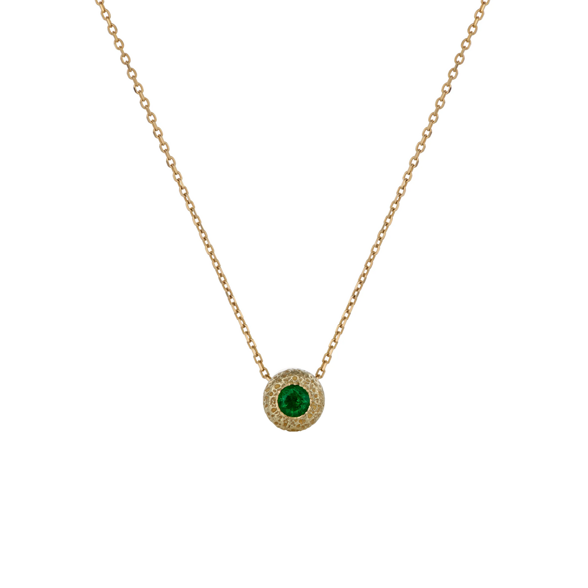 A delicate yellow gold chain necklace featuring a circular pendant with a central green emerald stone, set against a plain white background.