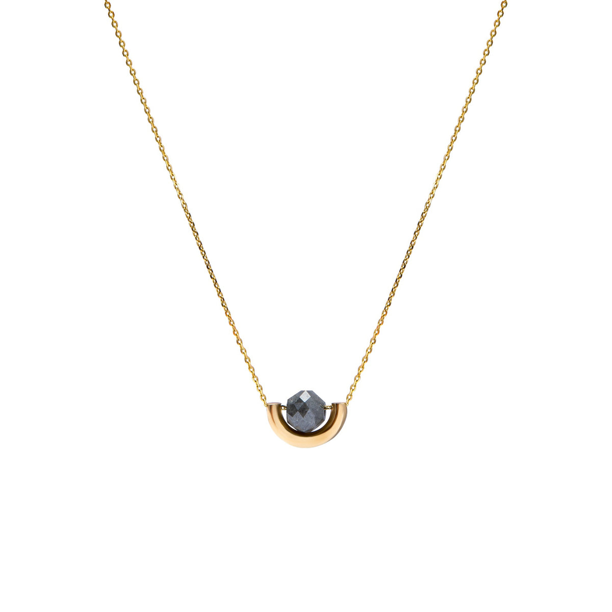 A delicate gold chain necklace featuring a small, polished gold crescent-shaped setting holding a round, dark gray diamond, presented on a solid white background.