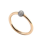 A minimalist yellow gold ring featuring a single, small, round grey faceted diamond, shown on a plain white background.