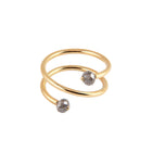 A yellow gold wrap ring featuring two faceted gray diamonds at the open ends, displayed on a clean white background.