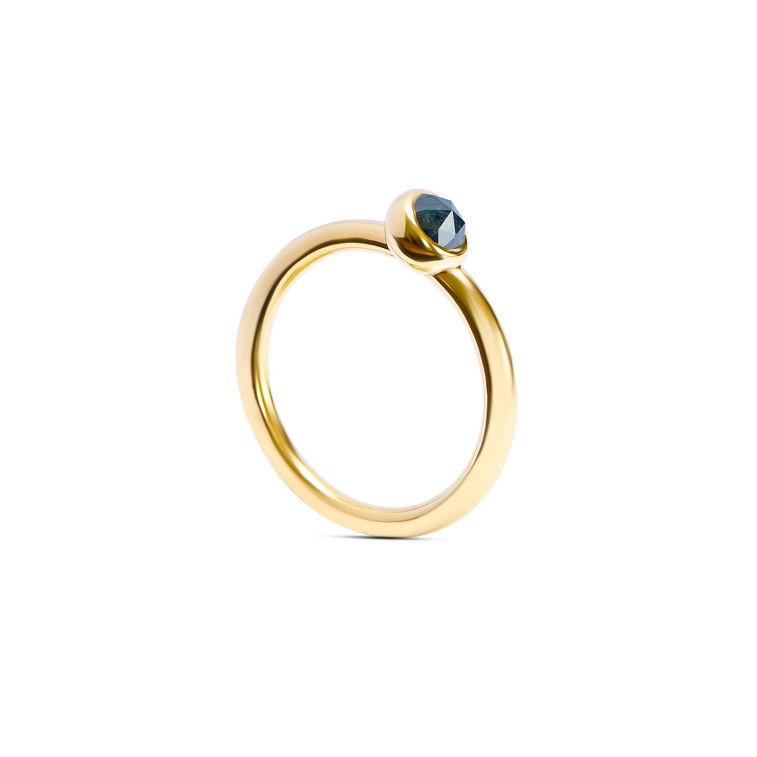 A yellow gold ring with a single faceted dark ocean blue gemstone in a bezel setting, shown on a clean white background.