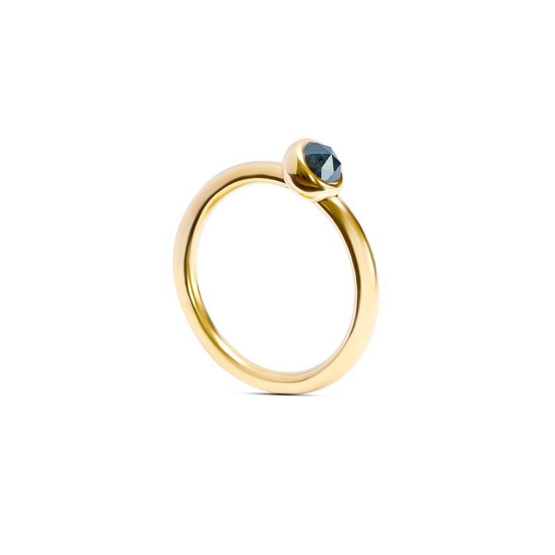A yellow gold ring with a single faceted dark ocean blue gemstone in a bezel setting, shown on a clean white background.