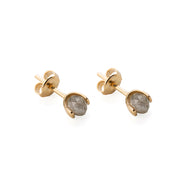A pair of gold stud earrings with faceted gray diamonds in a prong setting, shown on a clean white background.