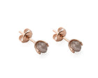 A pair of gold stud earrings with faceted gray diamonds in a prong setting, shown on a clean white background.