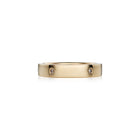 A slim yellow gold band ring with small brilliant diamonds set along it, photographed on a clean white background.