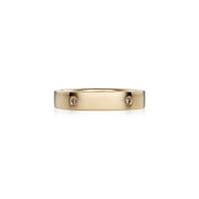 A slim yellow gold band ring with small brilliant diamonds set along it, photographed on a clean white background.