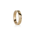 A polished yellow gold band ring with  small round-cut diamonds set on the side, shown against a clean white background with a soft reflection.