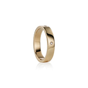 A polished yellow gold band ring with  small round-cut diamonds set on the side, shown against a clean white background with a soft reflection.