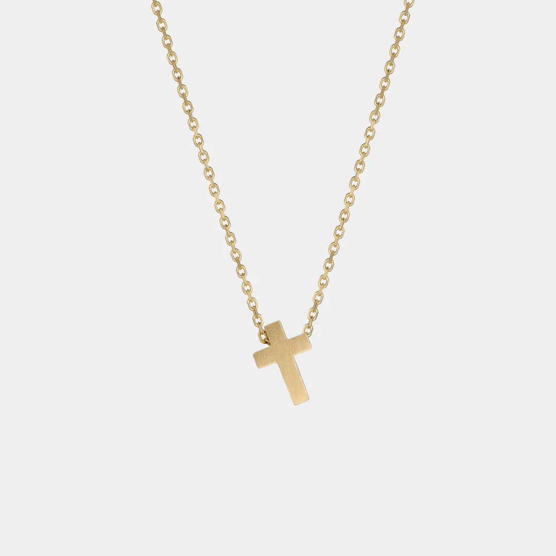 Yellow gold cross necklace on a white background