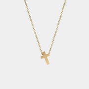 Yellow gold cross necklace on a white background