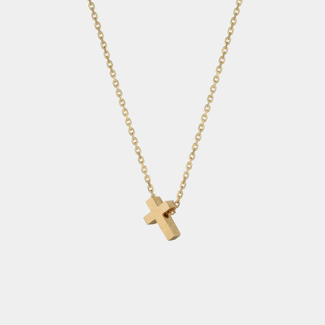 Yellow gold necklace with a small cross pendant on a white background